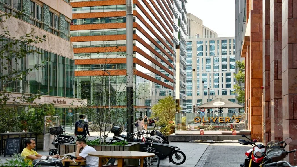 Moderne kantooromgeving aan de Gustav Mahlerlaan in Amsterdam met terrassen, fietsen en het Foz gebouw op de achtergrond.