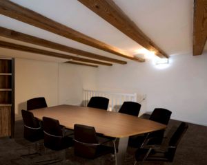 Vergaderruimte met houten balkenplafond en vergadertafel met acht stoelen in een kantoor aan de Herengracht 449a in Amsterdam.