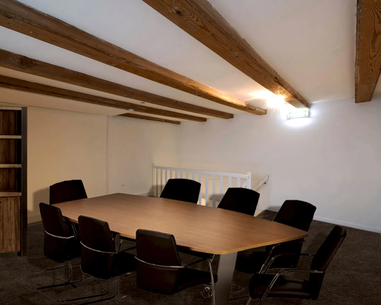 Vergaderruimte met houten balkenplafond en vergadertafel met acht stoelen in een kantoor aan de Herengracht 449a in Amsterdam.