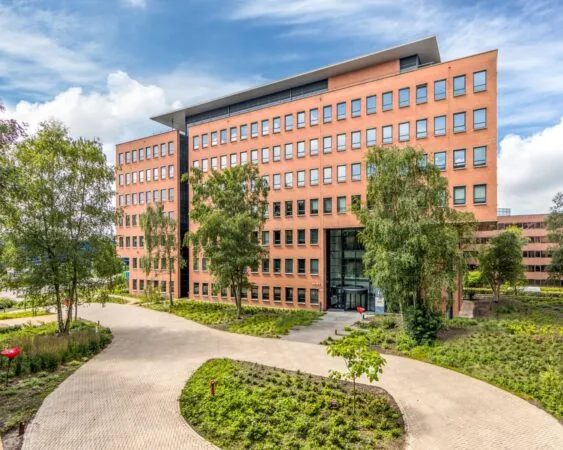 Modern kantoorgebouw aan de Hullenbergweg 81 in Amsterdam met een verzorgde groene omgeving.