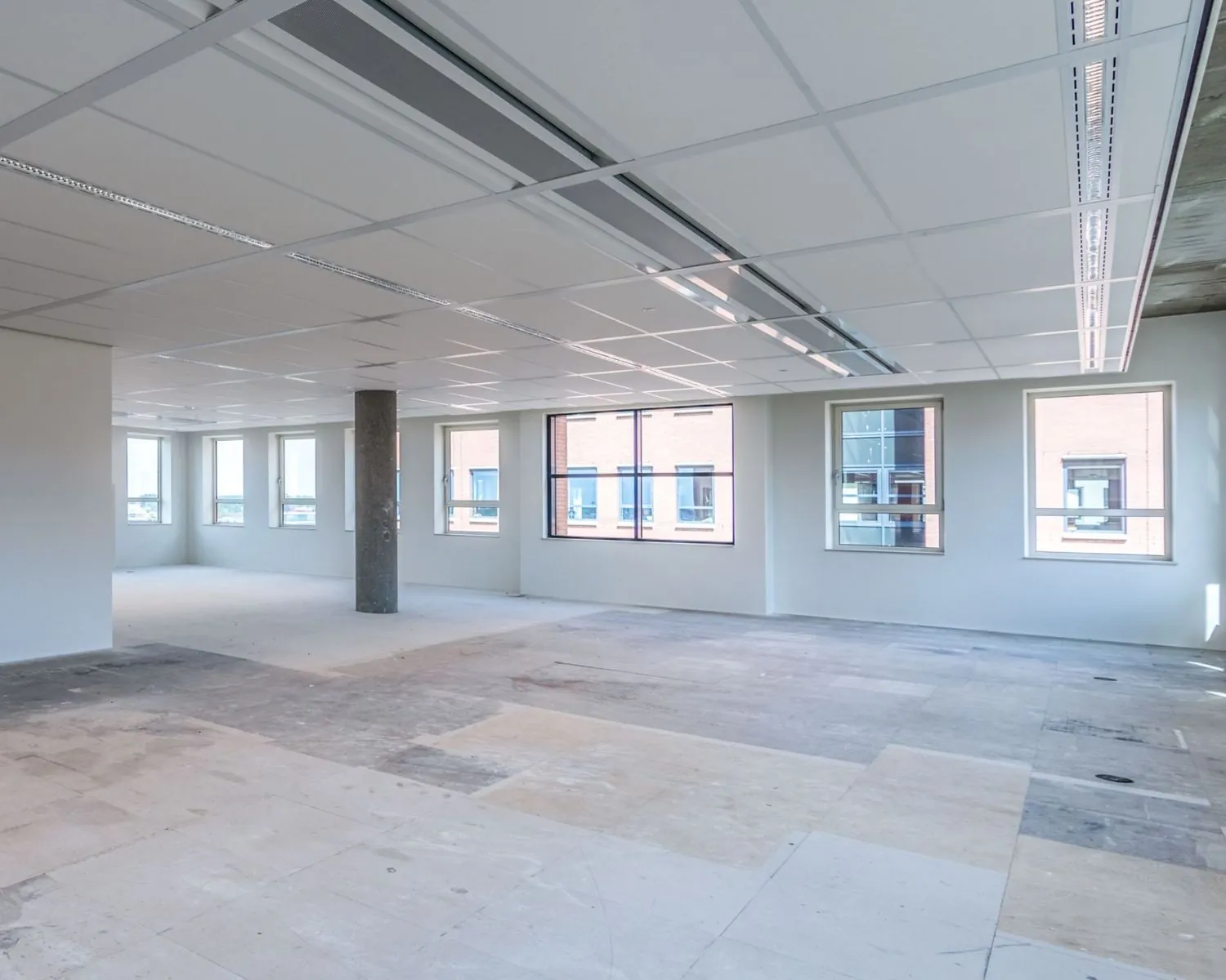 Lege kantoorruimte met systeemplafond en grote ramen aan de Hullenbergweg 81 in Amsterdam.