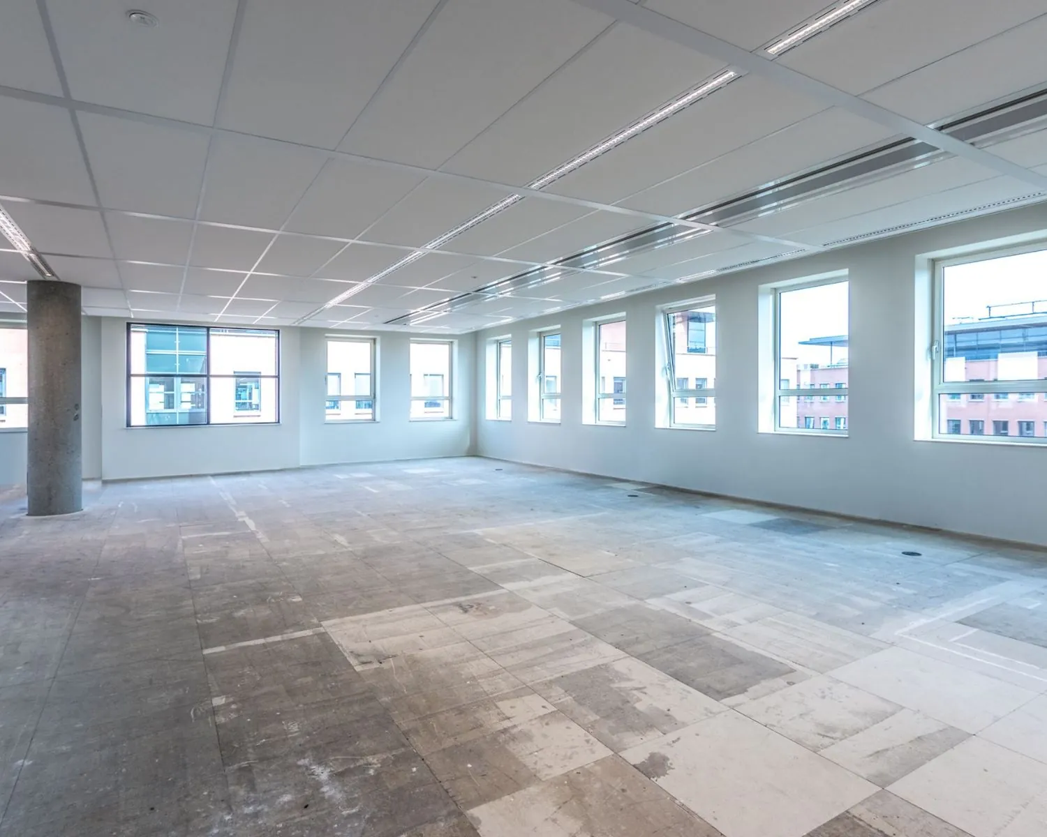 Lichte, ruime en lege kantoorruimte te huur aan de Hullenbergweg 81 in Amsterdam, met grote ramen en systeemplafond.