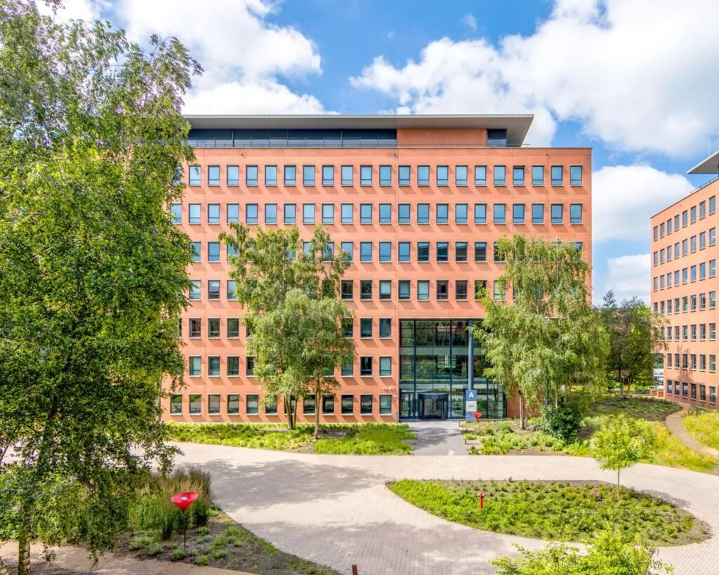 Voorzijde van een modern kantoorgebouw aan de Hullenbergweg 81 in Amsterdam, omringd door groen.