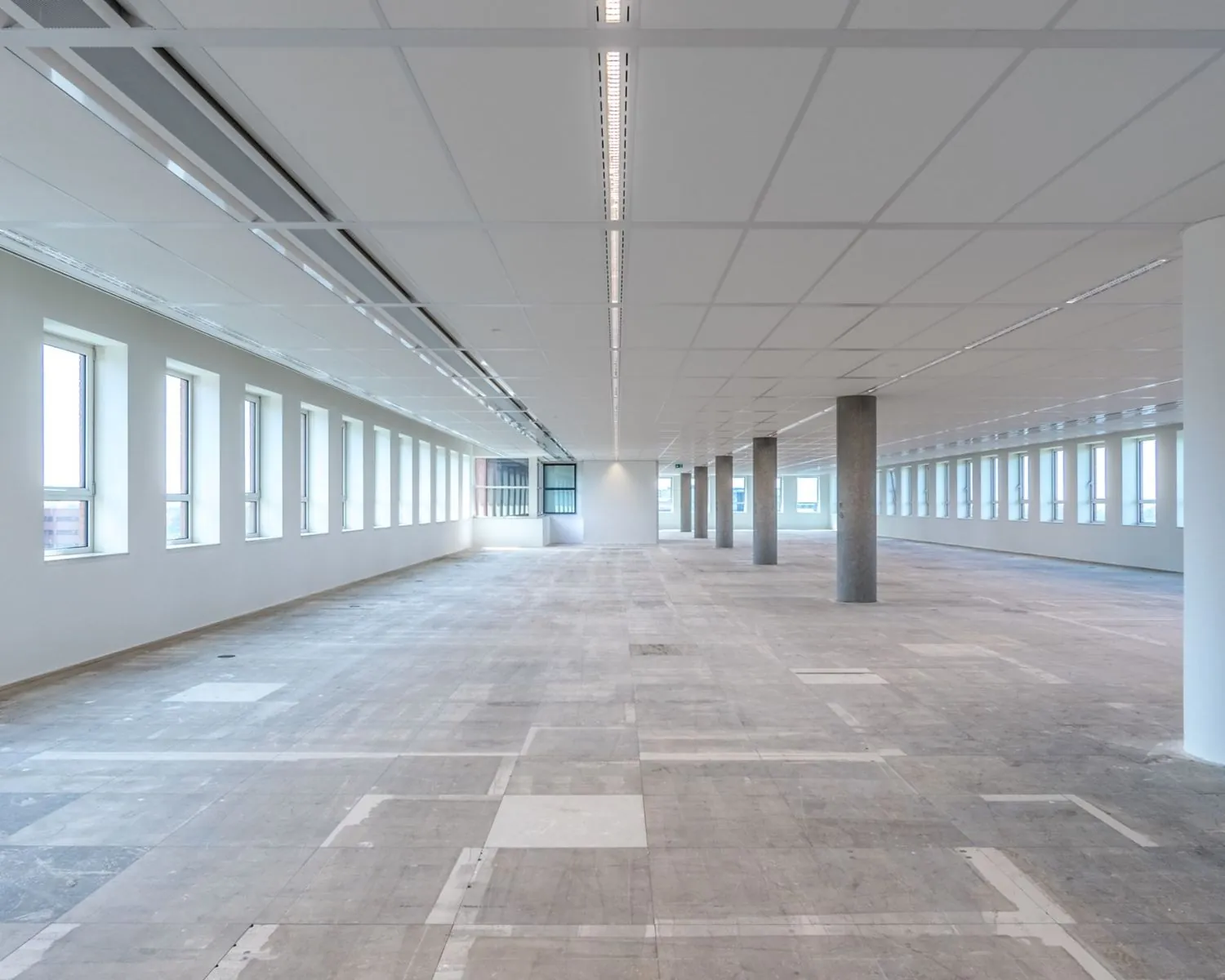 Leegstaande kantoorruimte met grote ramen aan de Hullenbergweg 81 in Amsterdam.