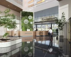 Moderne kantoorlobby in het Keynes Building met een groene wand, receptiebalie en veel natuurlijk licht aan het John M. Keynesplein 10 in Amsterdam.