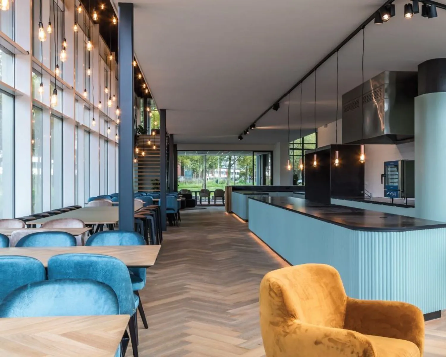 Moderne kantoorruimte met open keuken, zithoeken en grote ramen aan het John M. Keynesplein 10 in Amsterdam.