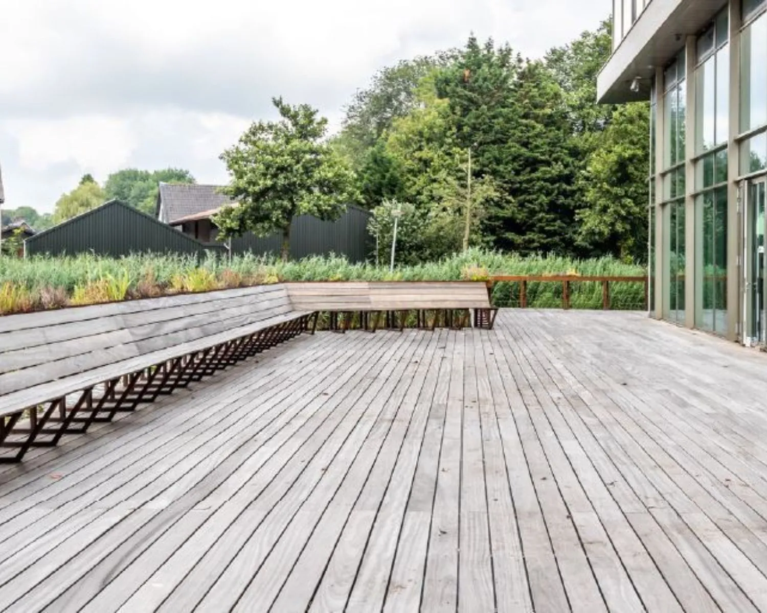 Houten terras met geïntegreerde zitbanken bij kantoorpand aan het John M. Keynesplein in Amsterdam.