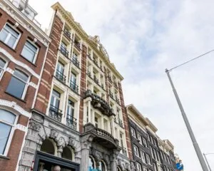 Historisch kantoorpand aan de Prins Hendrikkade 21 in Amsterdam met een klassieke gevel en smeedijzeren balkons.