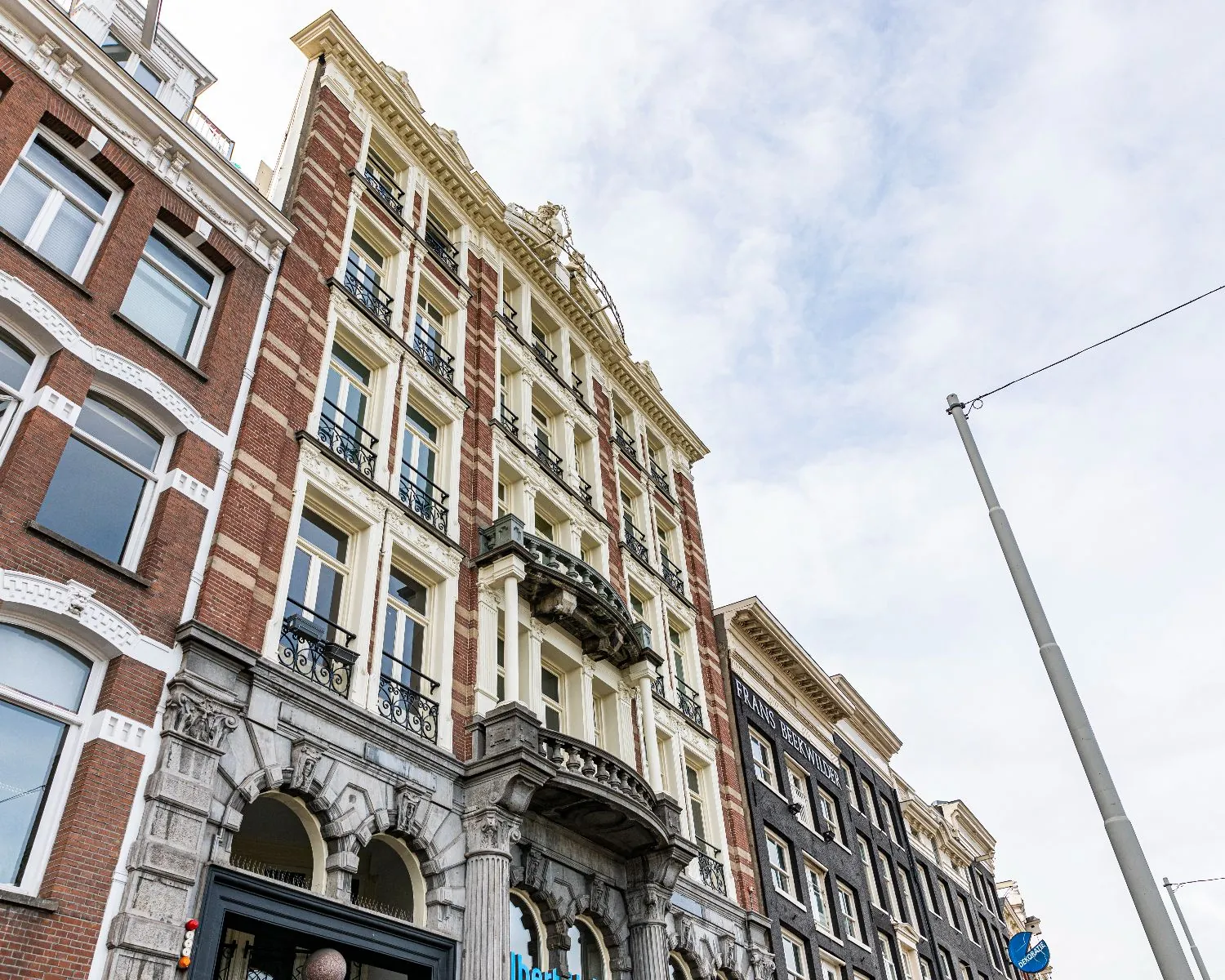 Historisch kantoorpand aan de Prins Hendrikkade 21 in Amsterdam met een klassieke gevel en smeedijzeren balkons.