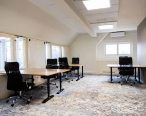 Lichte kantoorruimte met meerdere bureaus en bureaustoelen aan de Prins Hendrikkade 21 in Amsterdam.