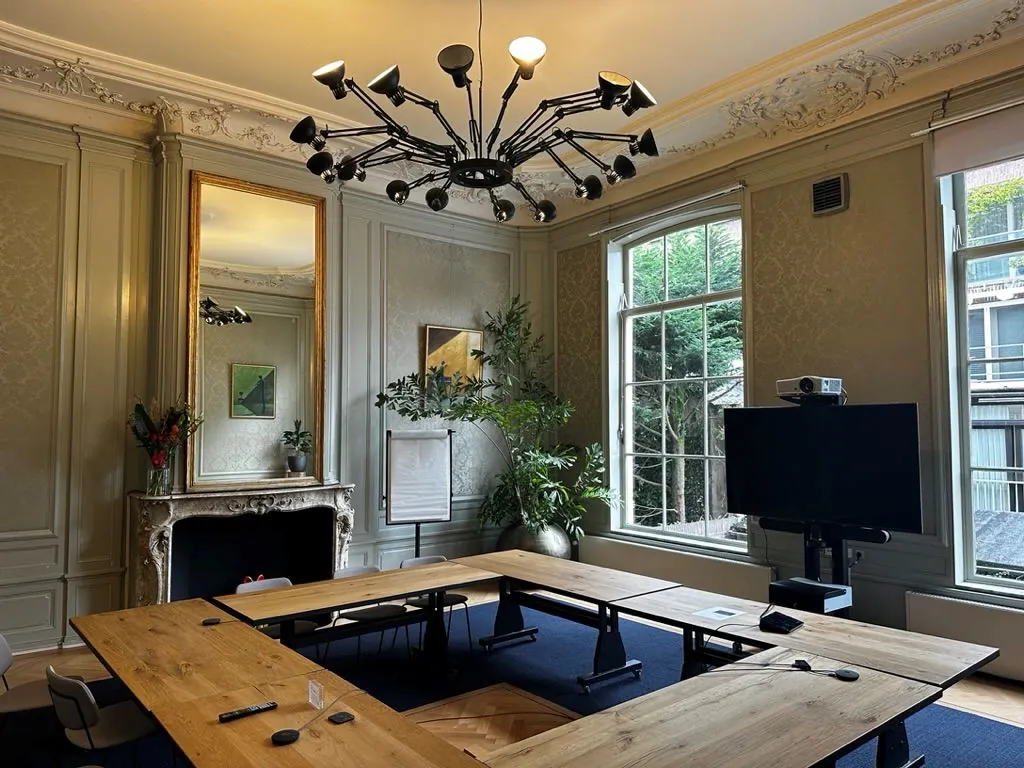 Vergaderruimte met klassieke inrichting, moderne vergaderfaciliteiten en uitzicht op de binnentuin aan het Singel 126-130 in Amsterdam.
