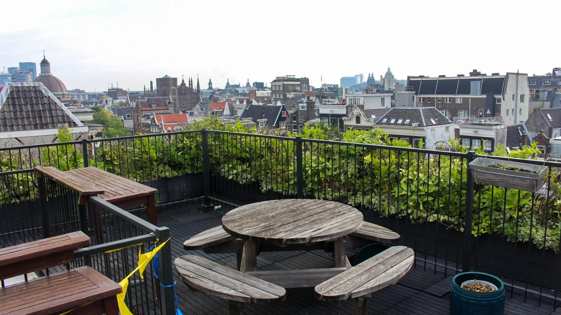 Dakterras met houten zitgelegenheid en uitzicht op de Amsterdamse binnenstad, bij kantoorruimte aan Singel 126-130.
