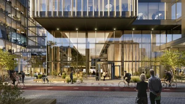 Moderne kantoorruimte aan de Strawinskylaan 1-2 in Amsterdam met glazen gevel, fietsers op de voorgrond en levendige openbare ruimte.