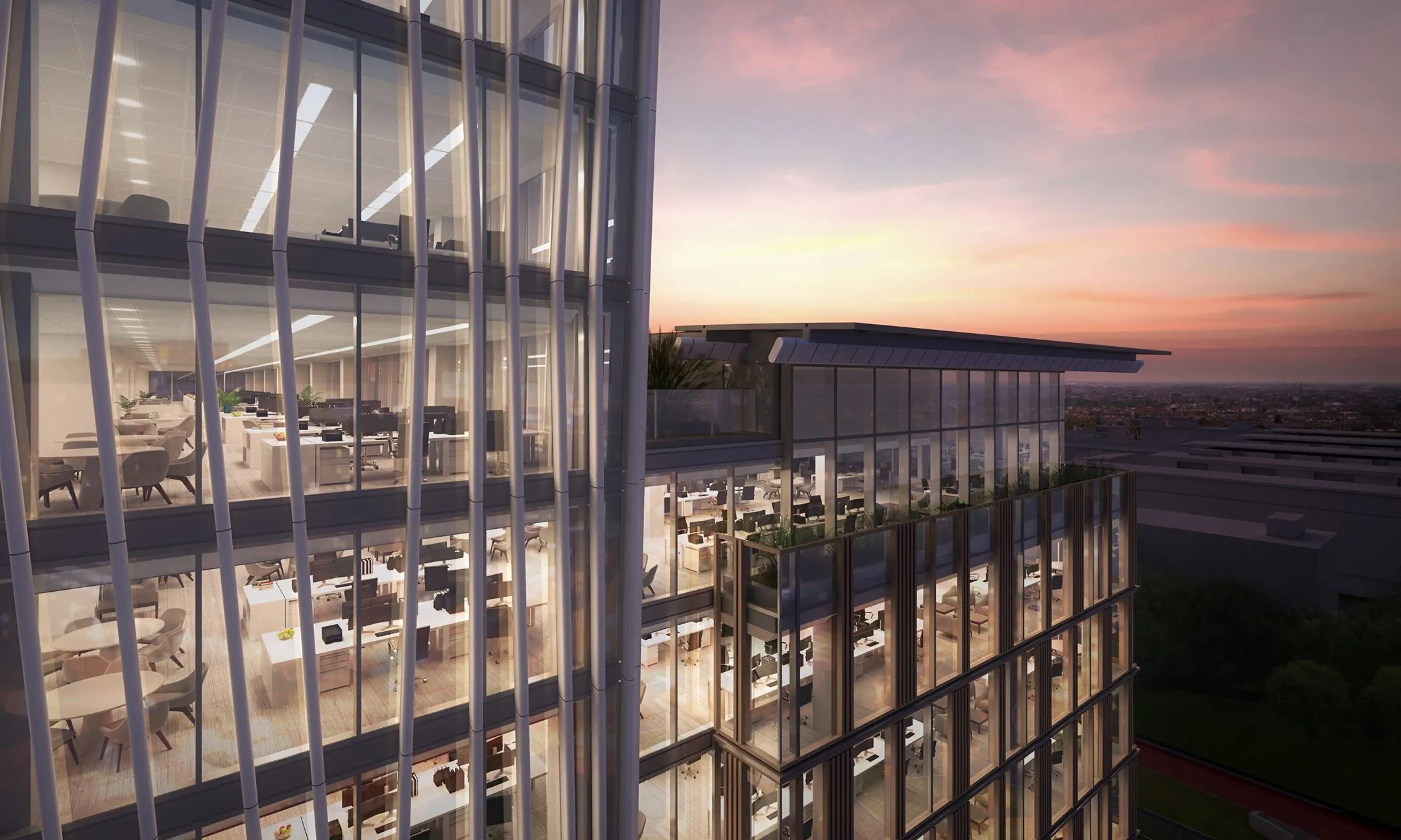 Moderne kantoorruimtes in een glazen kantoorgebouw aan de Strawinskylaan 1-9 in Amsterdam bij zonsondergang.