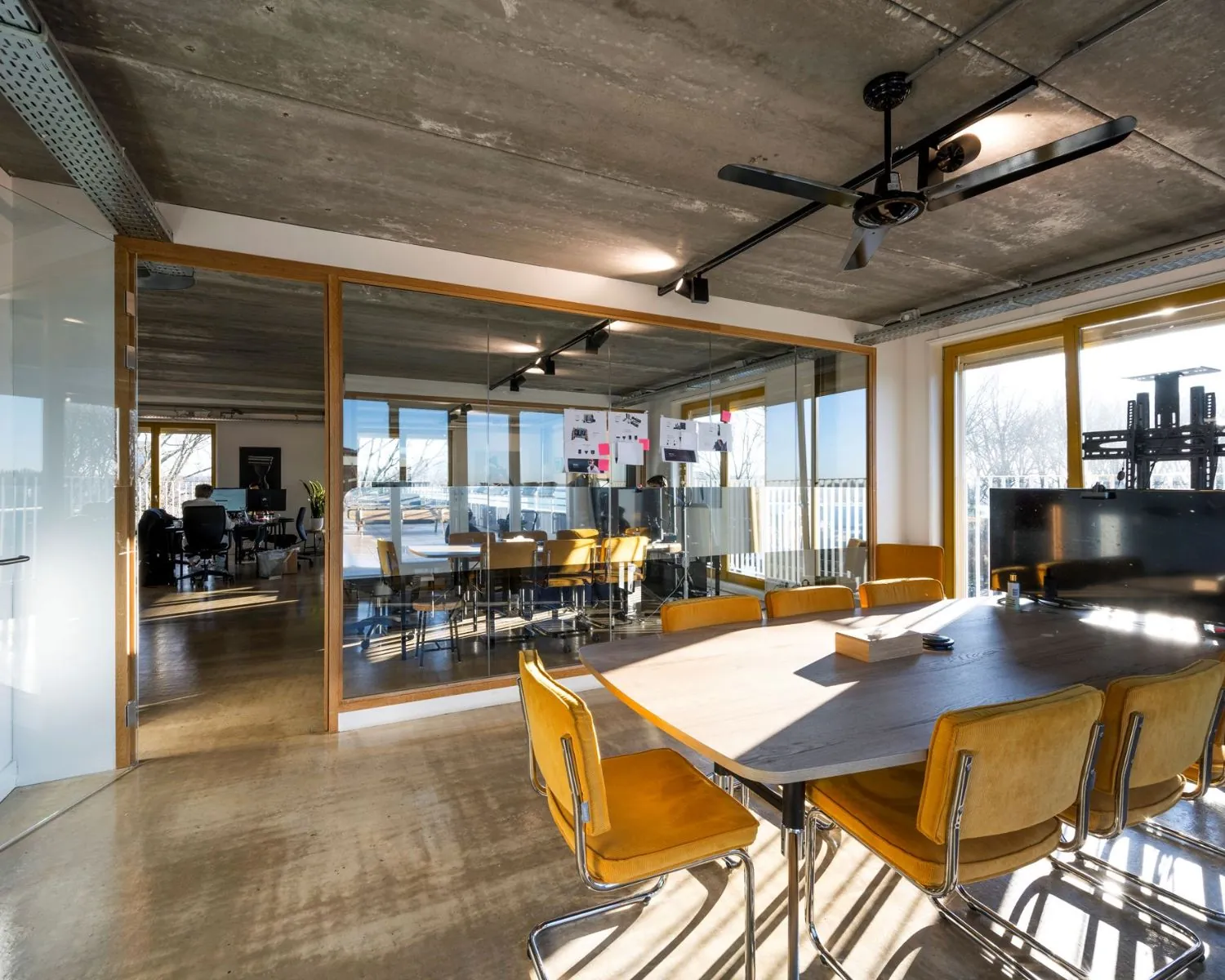 Moderne vergaderruimte met gele stoelen en glazen wanden in een kantoor aan de Vliegtuigstraat in Amsterdam.
