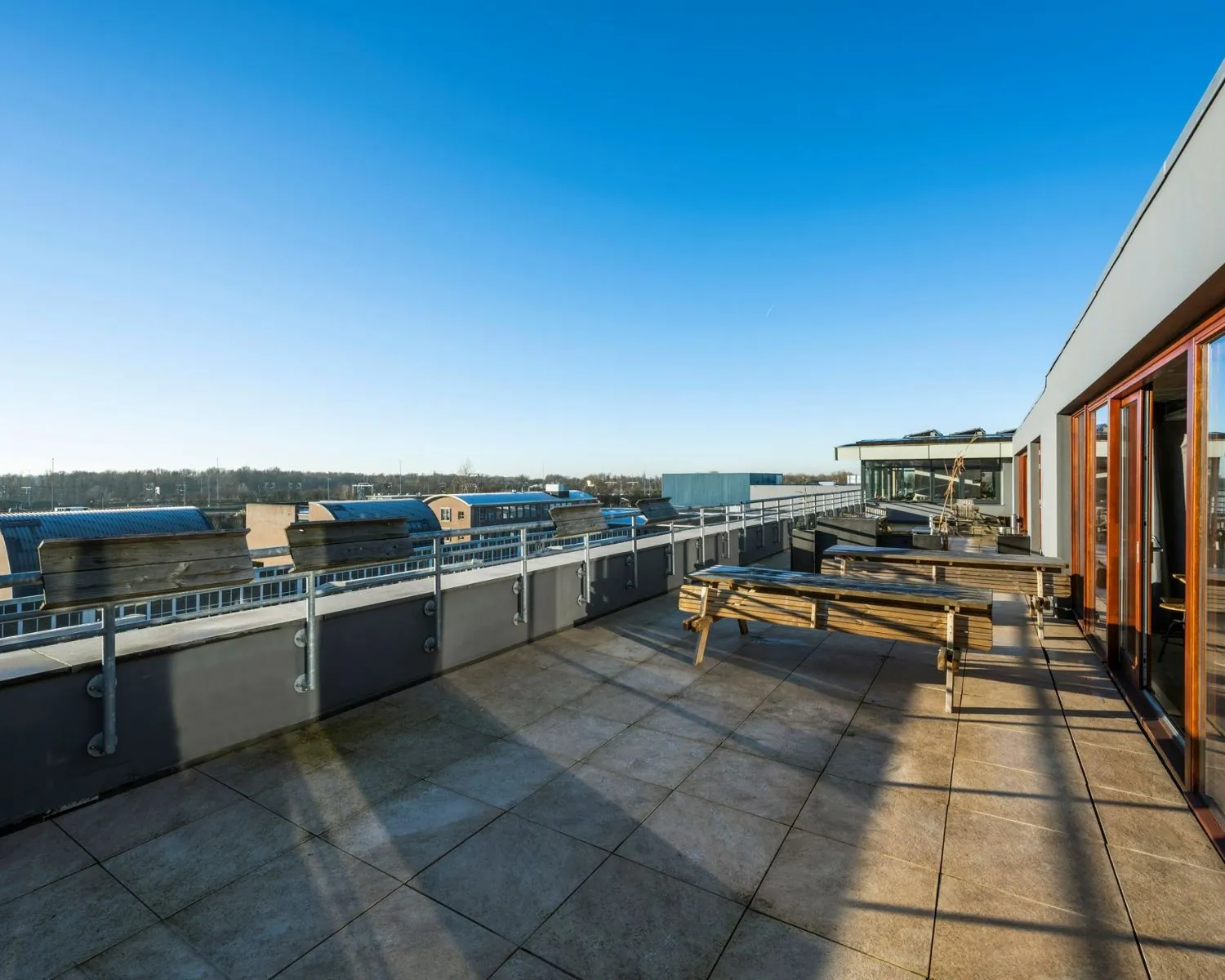 Ruim dakterras met picknicktafels bij kantoorruimte aan de Vliegtuigstraat 6-12 in Amsterdam.