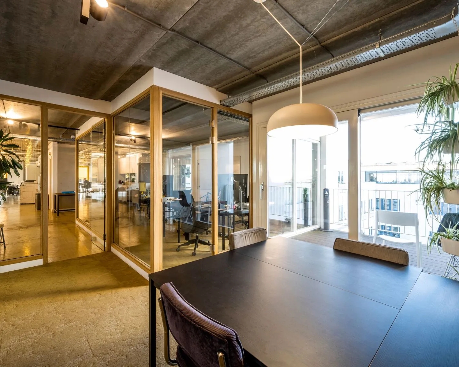 Moderne kantoorruimte met glazen vergaderruimtes en veel daglicht aan de Vliegtuigstraat 6-9 in Amsterdam.