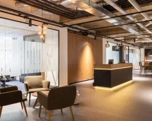 Moderne kantoorruimte met ontvangstbalie, zithoek en glazen wanden aan de Weerdestein 97 in Amsterdam.