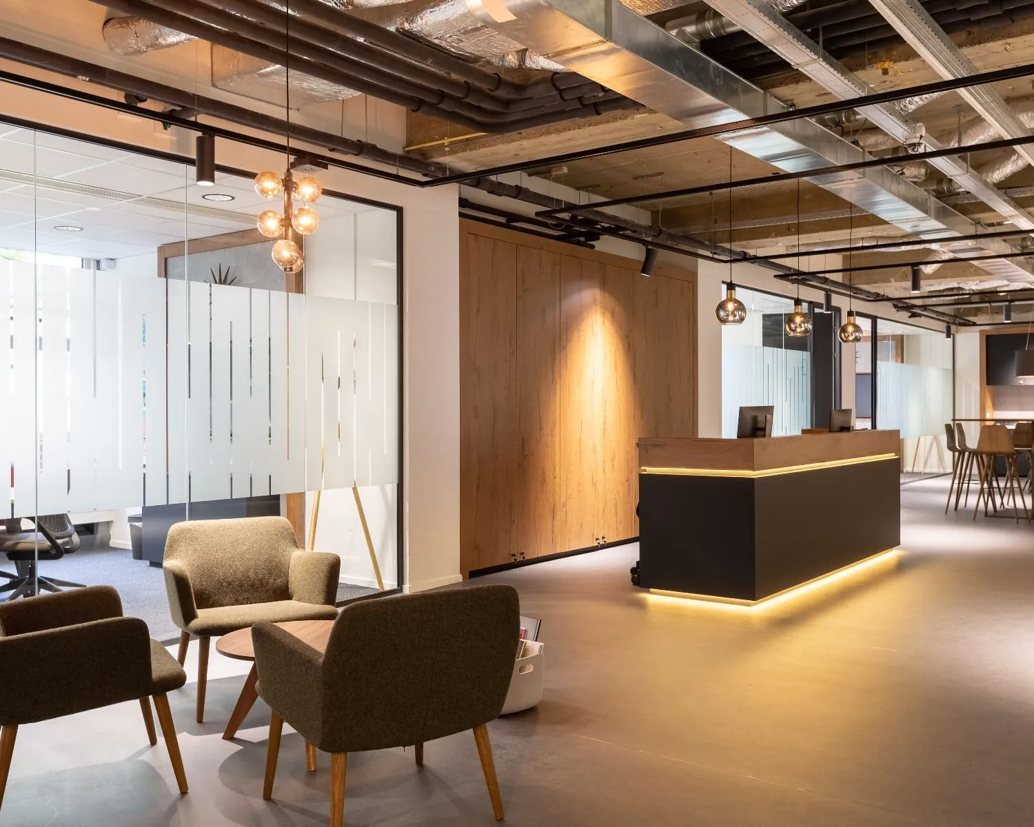 Moderne kantoorruimte met ontvangstbalie, zithoek en glazen wanden aan de Weerdestein 97 in Amsterdam.