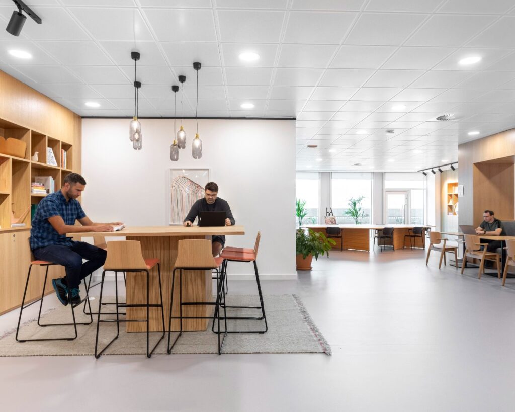 Moderne en lichte kantoorruimte aan de Haarlemmerweg 331 in Amsterdam met houten meubilair en werkplekken.