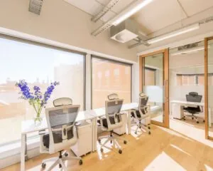 Lichte, moderne kantoorruimte met bureaus, bureaustoelen en grote ramen aan de Haarlemmerweg 331 in Amsterdam.