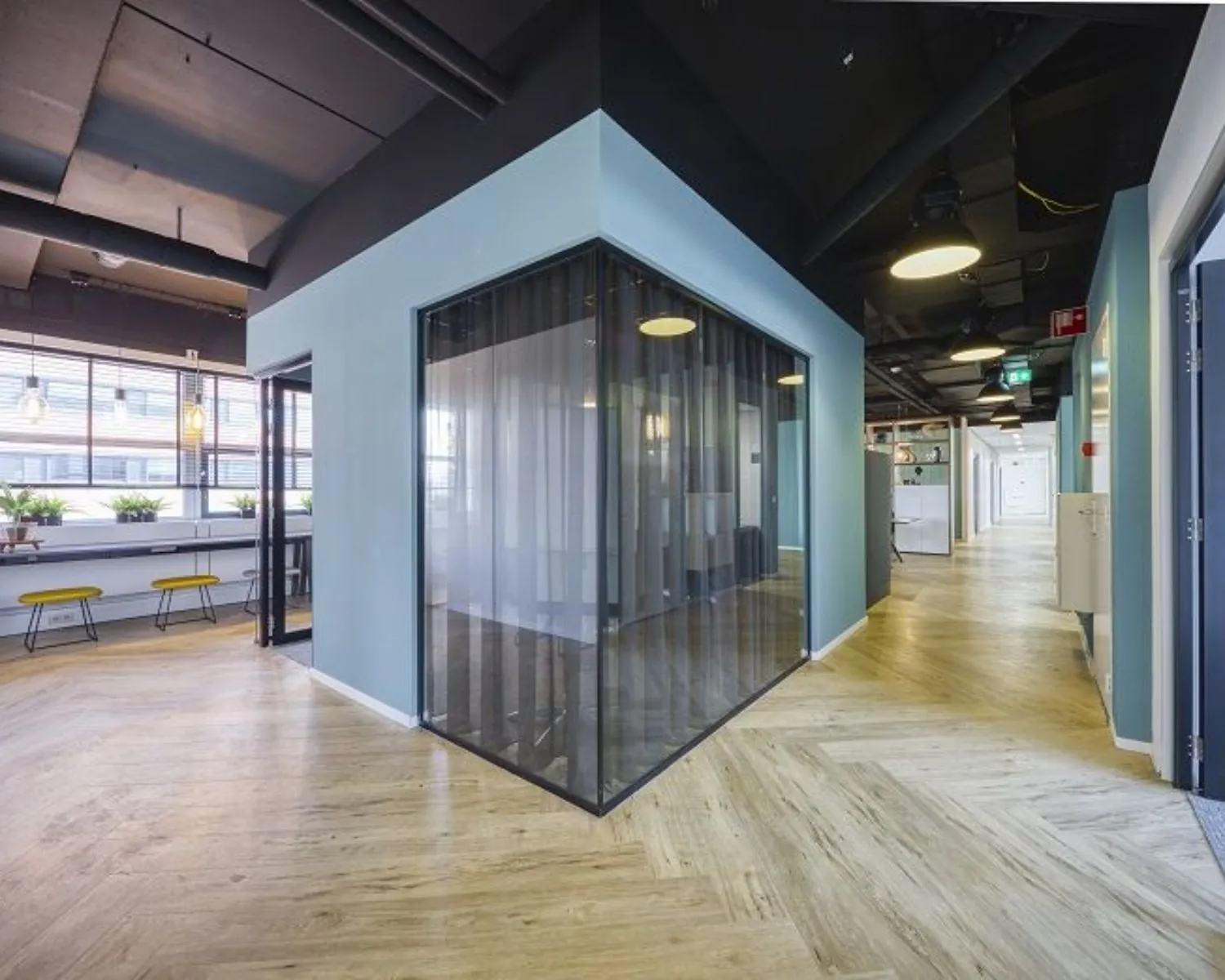 Moderne kantoorruimte met glazen vergaderruimte en houten visgraatvloer aan de Olof Palmeweg in Delft.