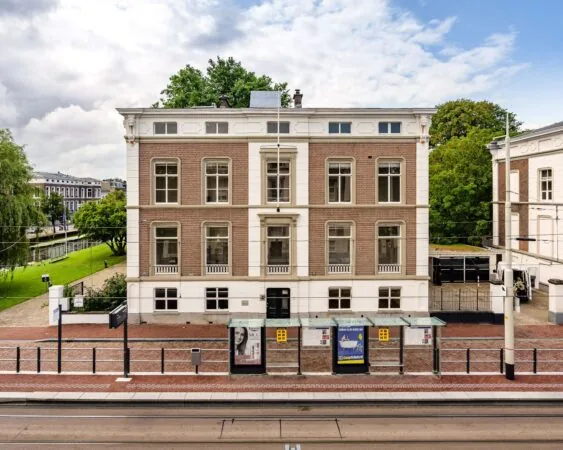 Voorgevel van een karakteristiek kantoorpand aan de Alexanderstraat 4-6 in Den Haag, met tramhalte op de voorgrond.