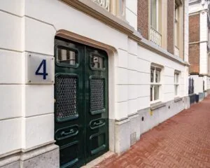 Voordeur van een kantoorruimte aan de Alexanderstraat 4 in Den Haag met statige gevel en huisnummerbord.