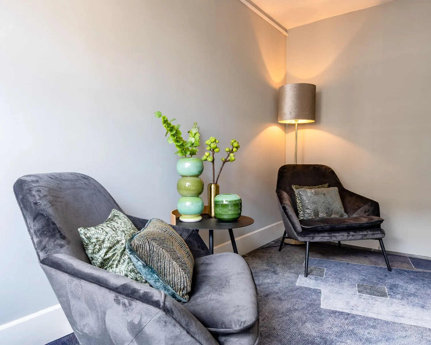 Stijlvol ingerichte loungehoek met twee fluwelen fauteuils en decoratieve kussens in een kantoorruimte aan de Alexanderstraat in Den Haag.