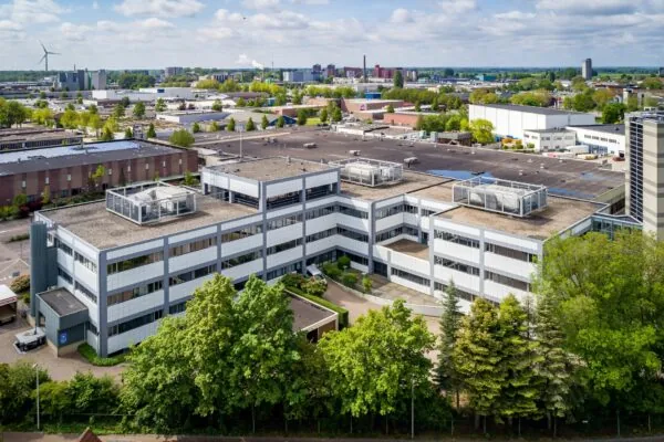 Luchtfoto van een modern kantoorpand aan de Staverenstraat 15-17 in Deventer, omgeven door groen en industriële bebouwing.