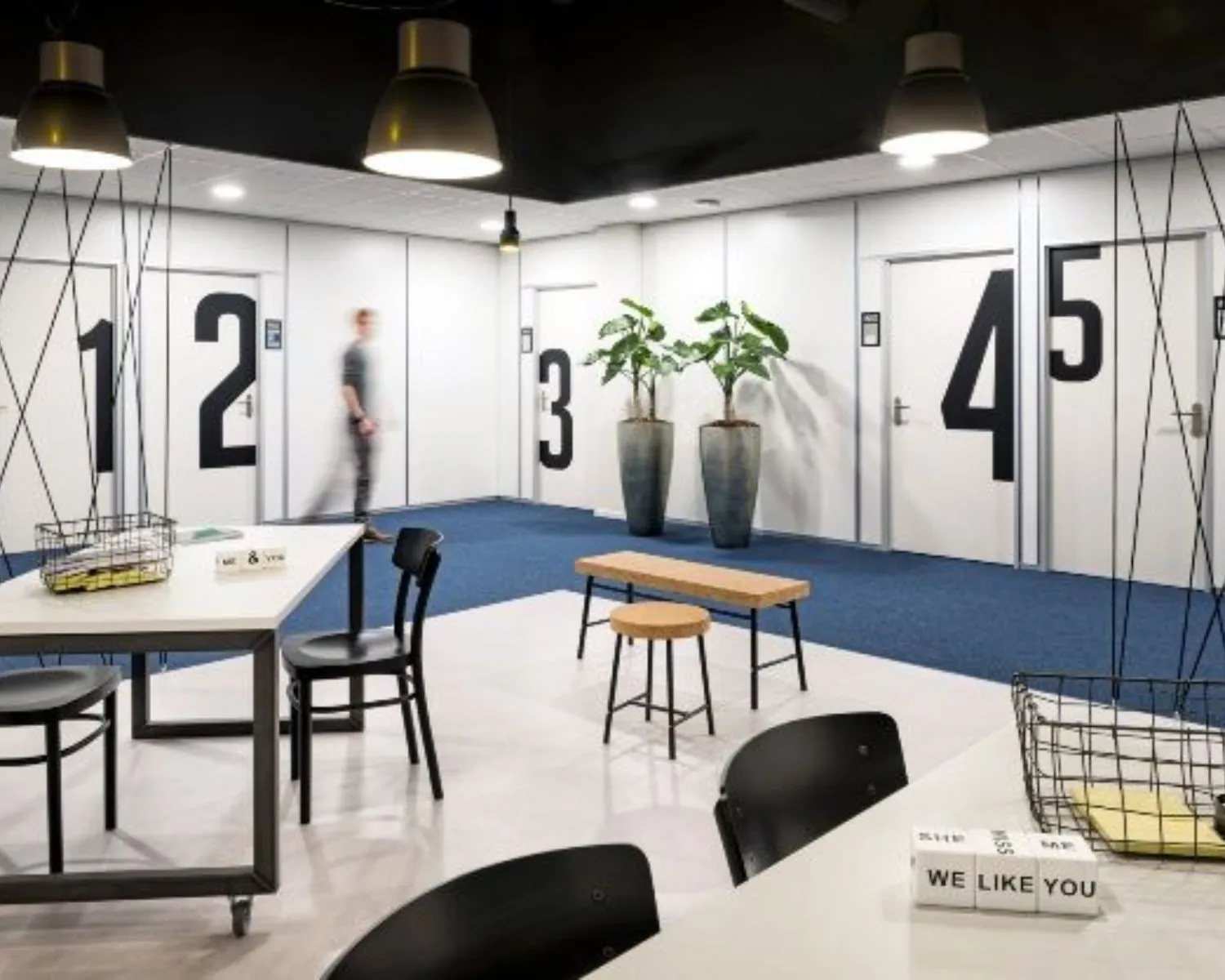 Moderne kantoorruimte aan de Europalaan in Den Bosch met genummerde deuren, werkplekken en planten.