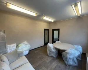 Kantoorruimte met ronde vergadertafel en stoelen in plastic, gelegen aan de Frans van Mierisstraat 50d in Amsterdam.