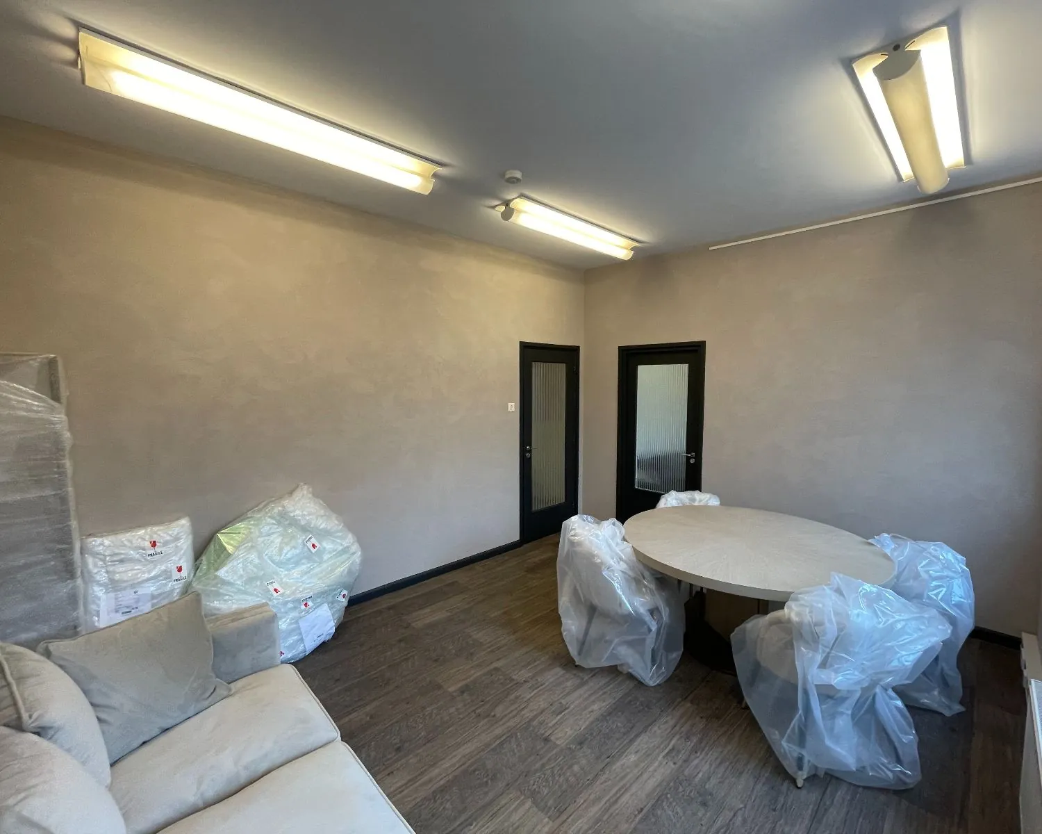 Kantoorruimte met ronde vergadertafel en stoelen in plastic, gelegen aan de Frans van Mierisstraat 50d in Amsterdam.