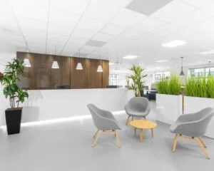 Moderne en lichte kantoorruimte in Hilversum met zithoek, receptiebalie en veel groen.