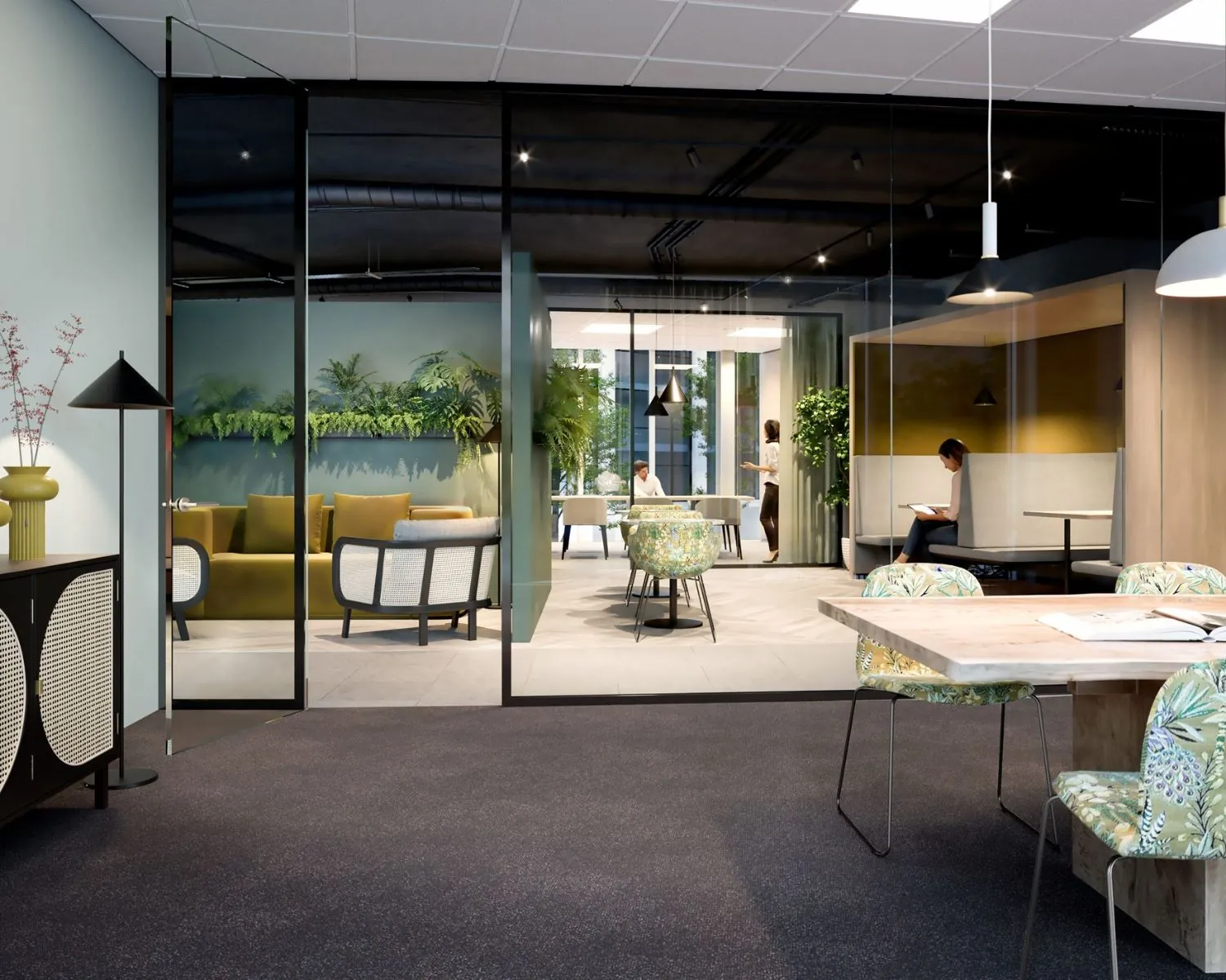 Moderne kantoorruimte in Leeuwarden met glazen wanden, loungesetjes, werkplekken en veel groen.