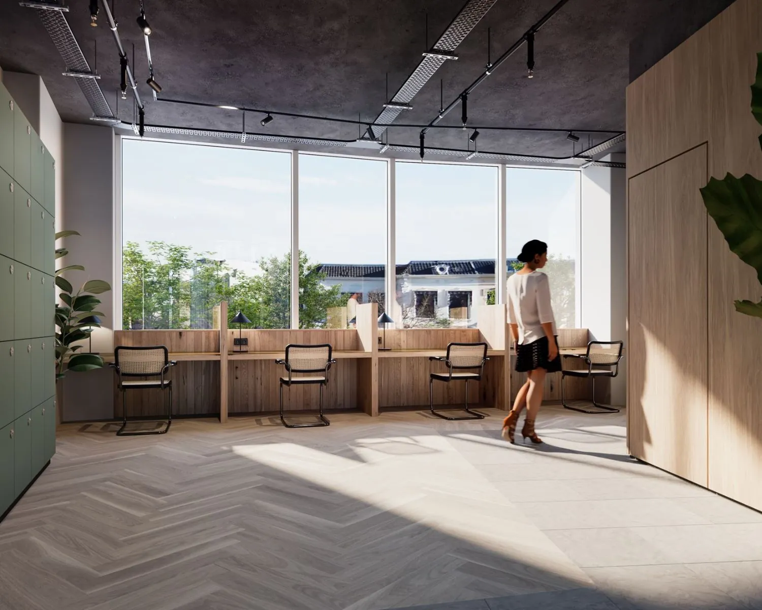 Moderne kantoorruimte in Leeuwarden met werkplekken aan het raam en een vrouw die voorbij loopt.
