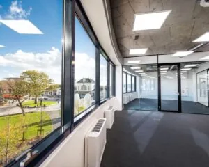 Moderne, lichte kantoorruimte met glazen wanden en uitzicht op het stationsplein van Leeuwarden aan de Lange Marktstraat.