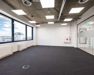 Moderne, lege kantoorruimte te huur aan de Lange Marktstraat 1-5 in Leeuwarden met grote ramen en glazen scheidingswand.