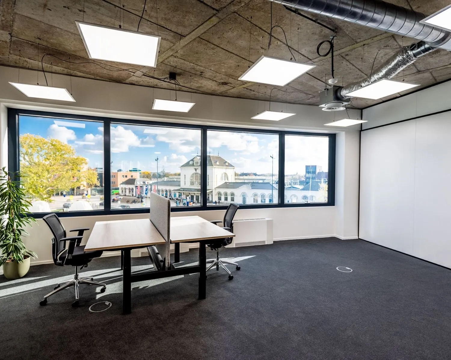 Moderne kantoorruimte met grote ramen en uitzicht op het stationsgebied van Leeuwarden aan de Lange Marktstraat.