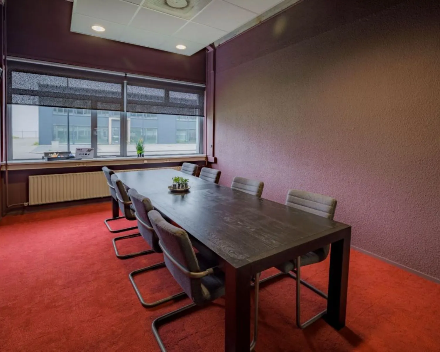Vergaderruimte met acht stoelen en een grote tafel in een kantoor aan de Oude Apeldoornseweg in Apeldoorn.