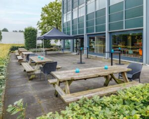 Terras met picknicktafels en stoelen bij kantoorpand aan de Oude Apeldoornseweg 41-45 in Apeldoorn.