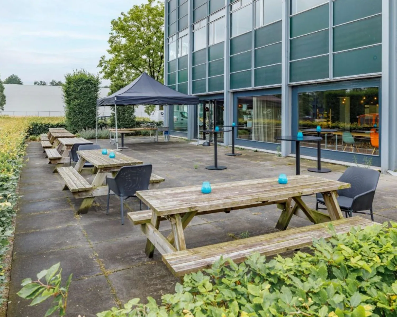 Terras met picknicktafels en stoelen bij kantoorpand aan de Oude Apeldoornseweg 41-45 in Apeldoorn.