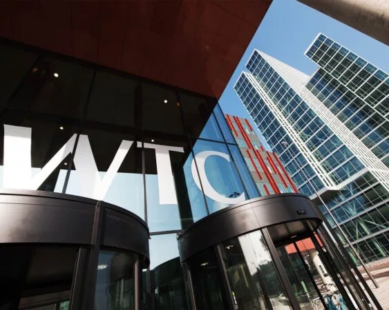 Entree van het WTC-gebouw aan de PJ Oudweg 4 in Almere met moderne glazen gevel en hoge kantoortorens.