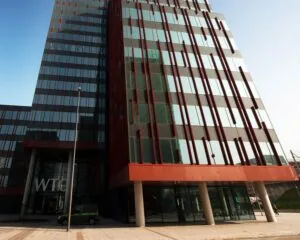 Voorgevel van het WTC-gebouw aan de PJ Oudweg 4 in Almere met moderne glazen en rode accenten.