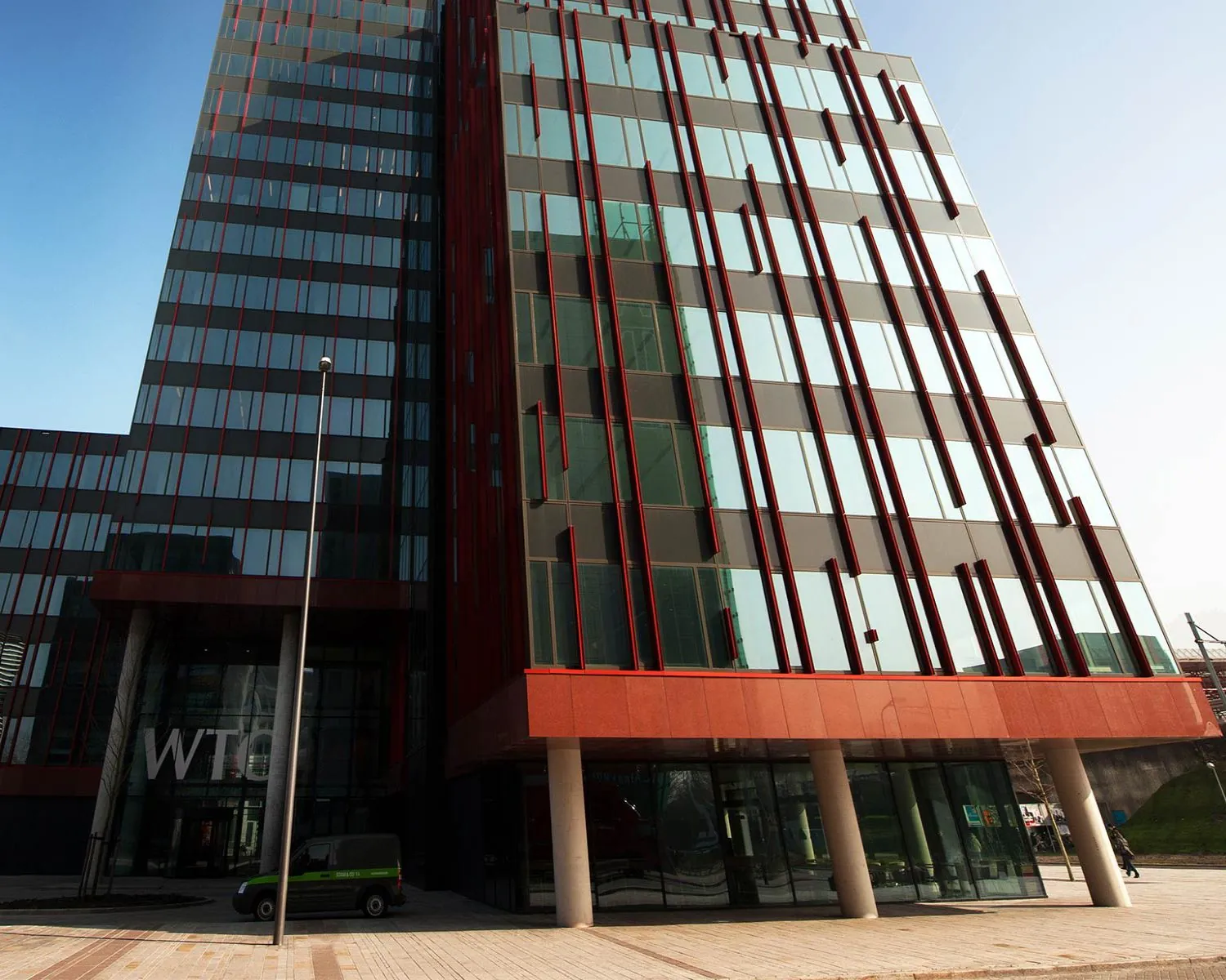 Voorgevel van het WTC-gebouw aan de PJ Oudweg 4 in Almere met moderne glazen en rode accenten.