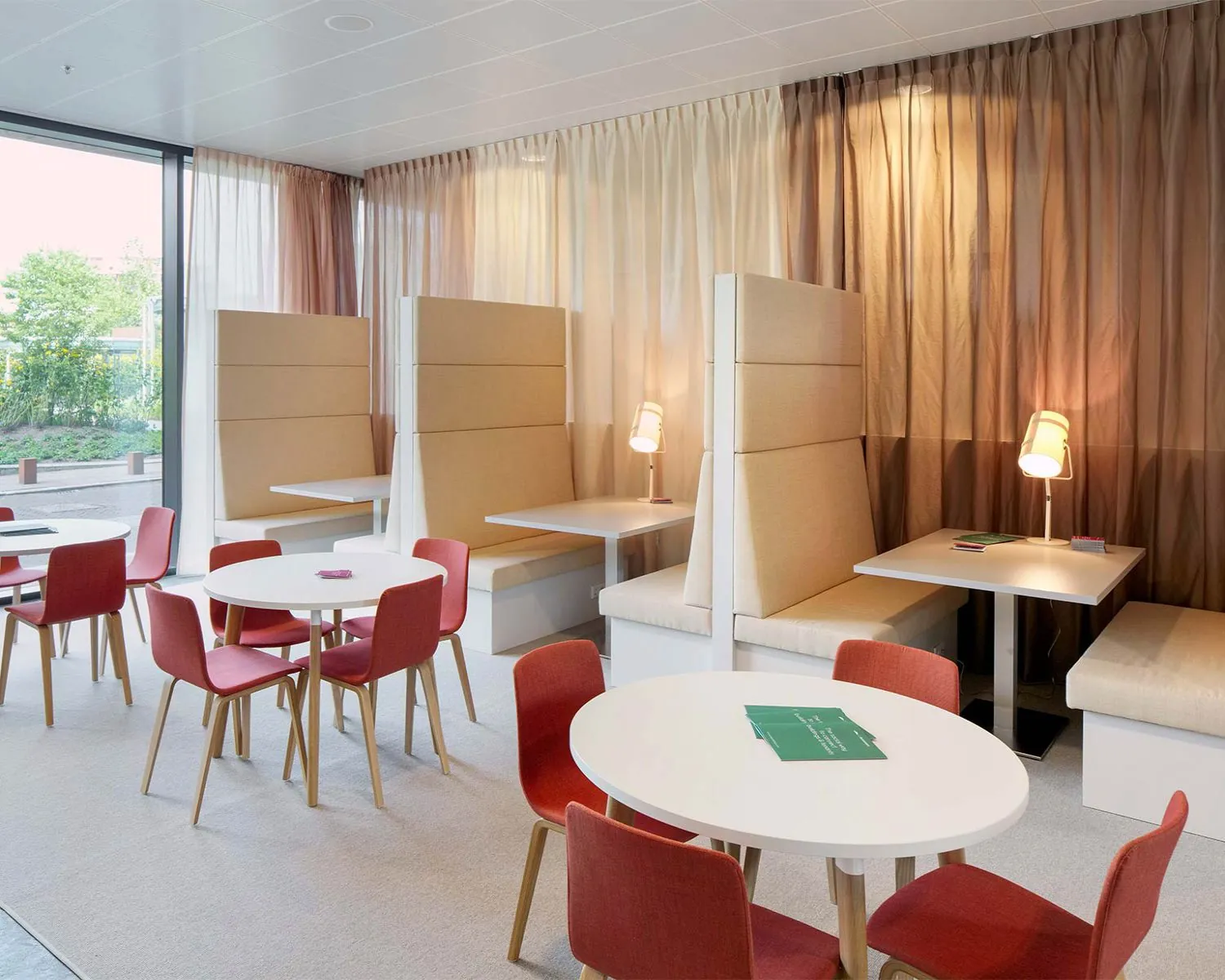 Moderne kantoorruimte in het WTC Almere met zitjes, vergadertafels en warme verlichting.