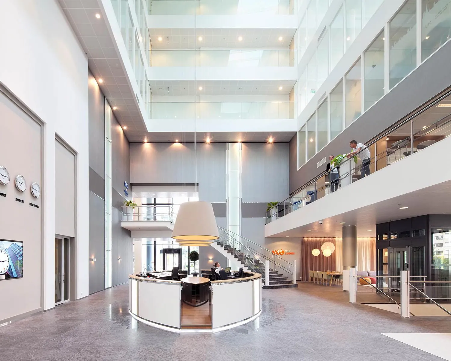 Moderne, lichte entreehal van het WTC-gebouw aan de PJ Oudweg 4 in Almere met een ronde receptiebalie en glazen wanden.