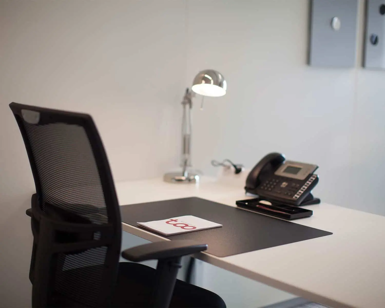 Moderne kantoorruimte met bureau, bureaustoel, bureaulamp en telefoontoestel in WTC Almere.