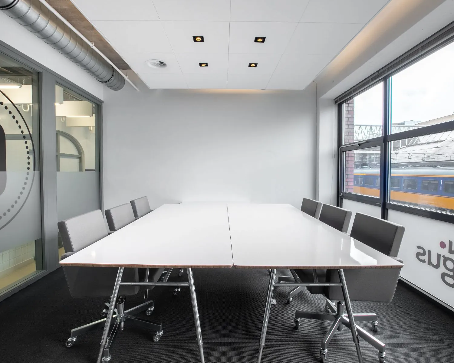 Moderne vergaderruimte met grote ramen en uitzicht op het station bij Piet Mondriaanplein 13.