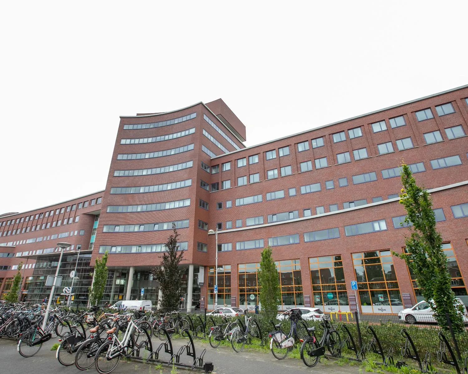 Modern kantoorgebouw aan het Piet Mondriaanplein 13-8 met meerdere verdiepingen en fietsenstalling op de voorgrond.